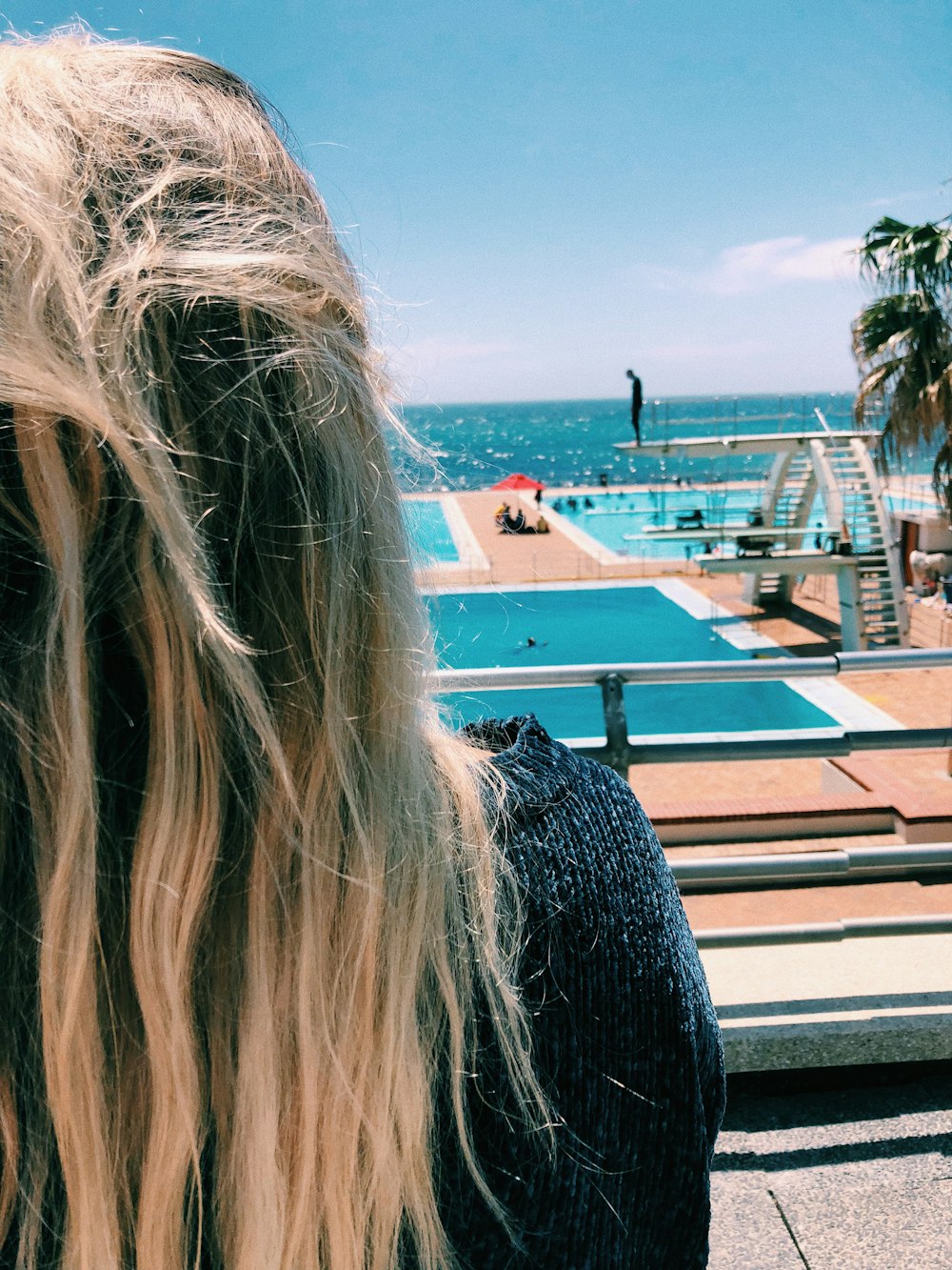 Mujer frente a la piscina cerca del mar durante el día