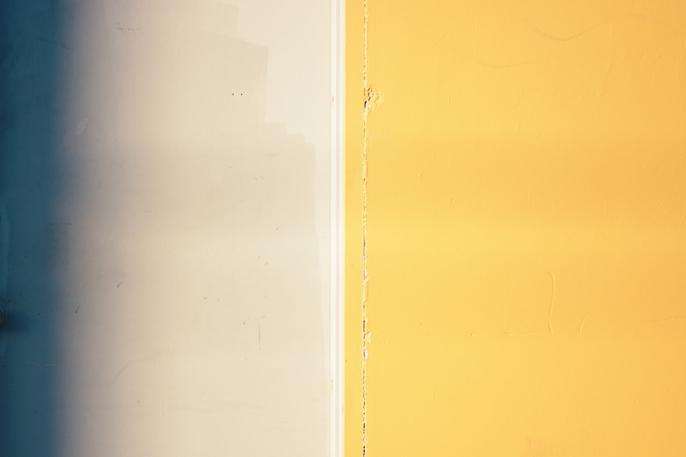 a yellow and blue wall with a white door