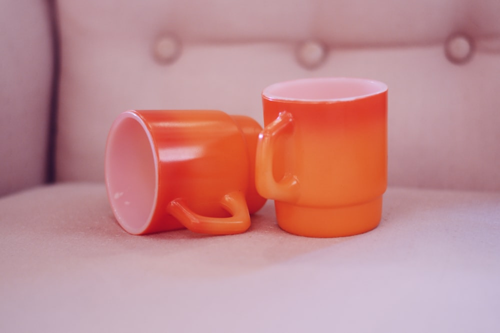 two empty orange-and-white mugs