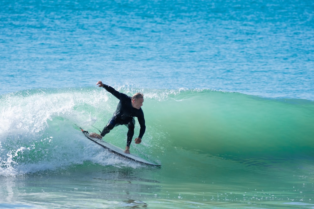 man surfing on sea during daytime