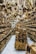A store filled with numerous wooden items displayed on shelves and hanging from the ceiling. The assortment includes spoons, bowls, cutting boards, and various kitchen utensils made from wood. The arrangement creates a dense and rustic atmosphere.