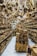 A store filled with numerous wooden items displayed on shelves and hanging from the ceiling. The assortment includes spoons, bowls, cutting boards, and various kitchen utensils made from wood. The arrangement creates a dense and rustic atmosphere.
