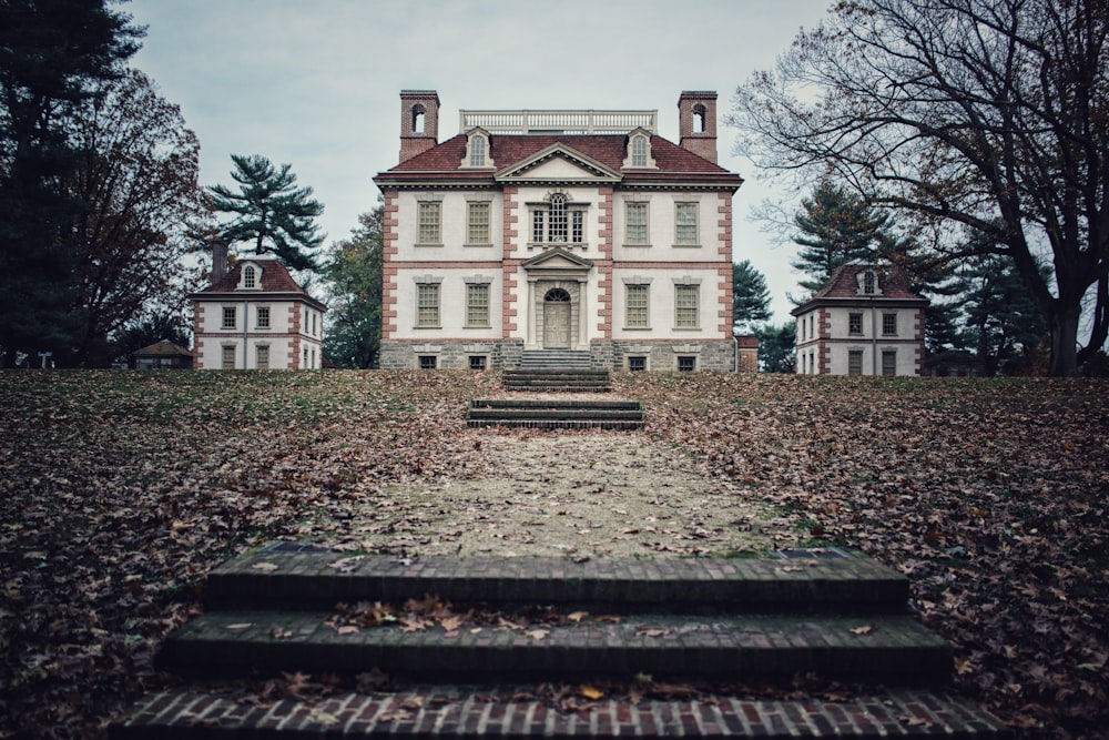 Casa branca e marrom de 4 andares na frente da árvore