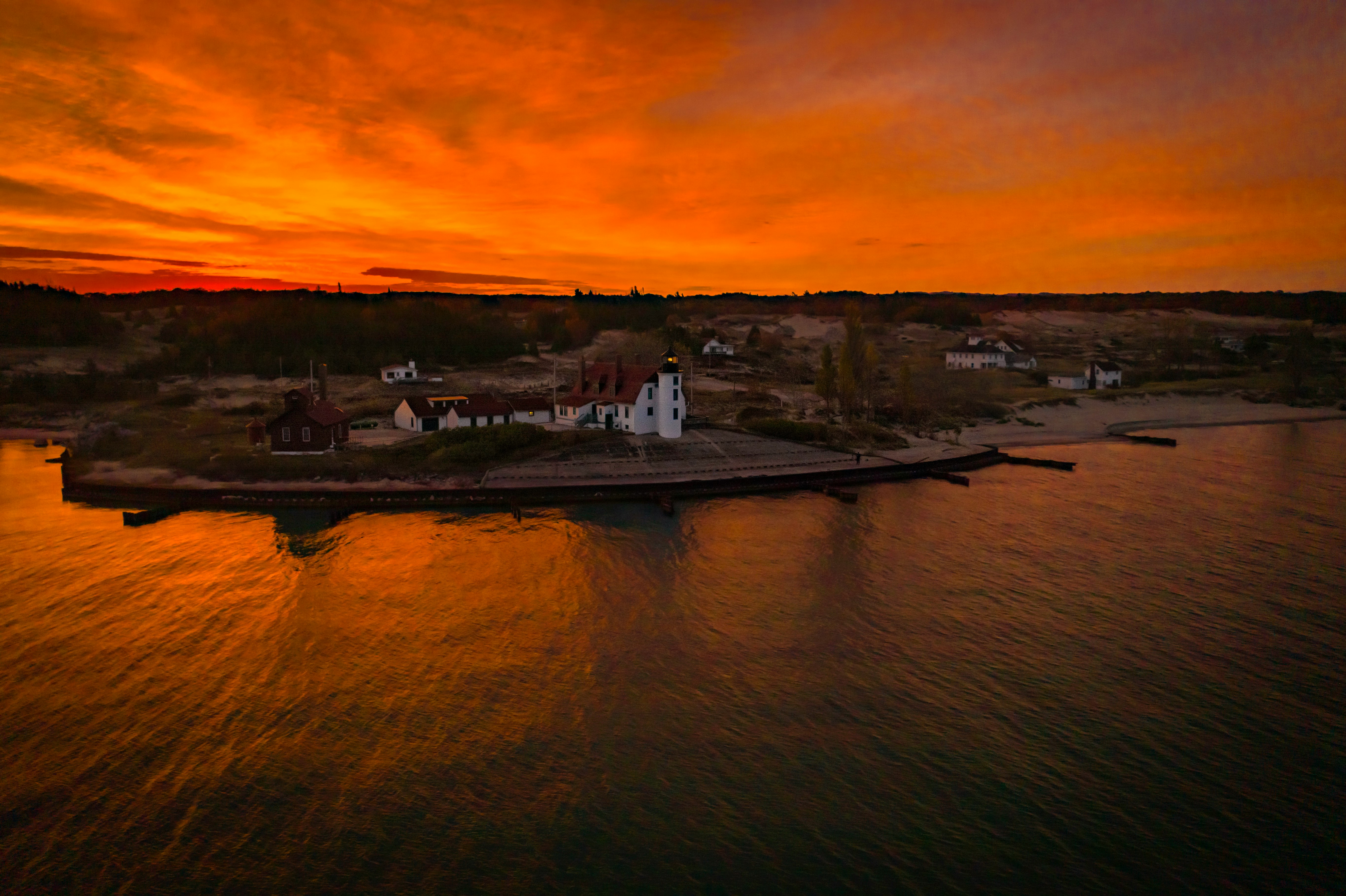 aerial photography of white building beside body of water under cloudy sky during golden hour