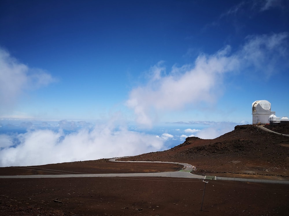 Route grise près d’un bâtiment gris sous un ciel bleu clair pendant la journée