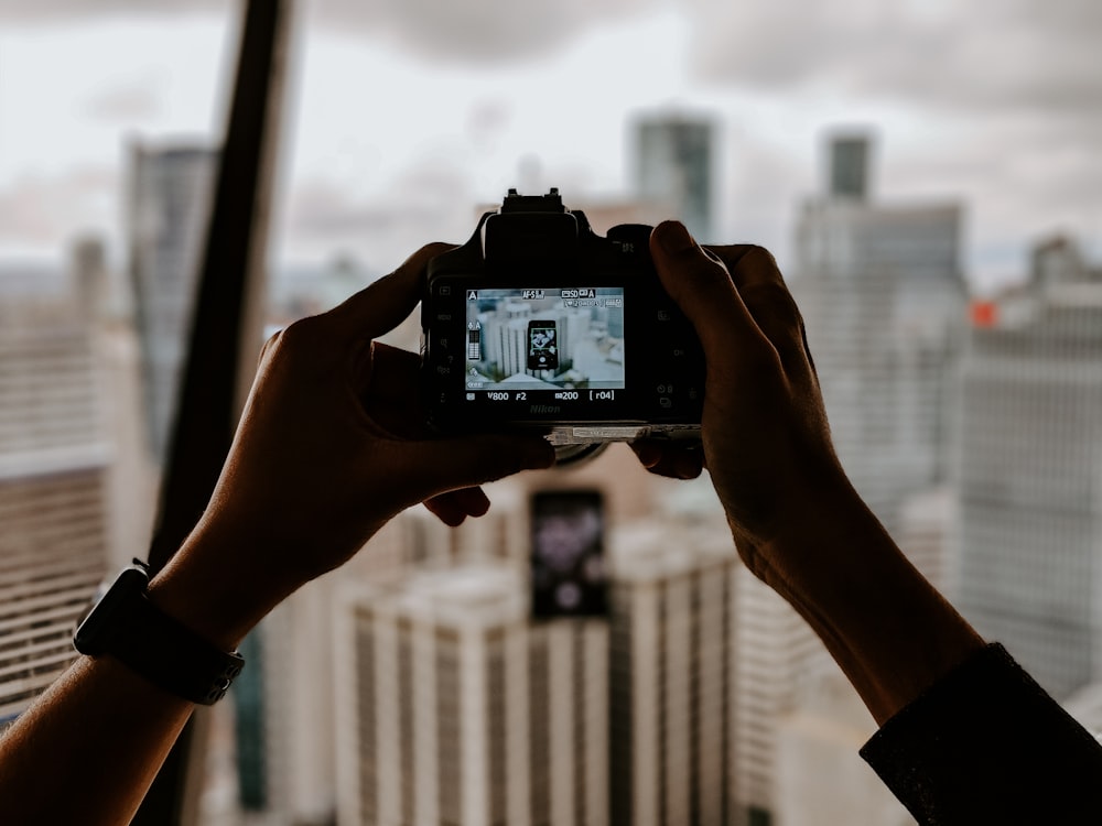 focus photography of DSLR camera talking photo of buildings