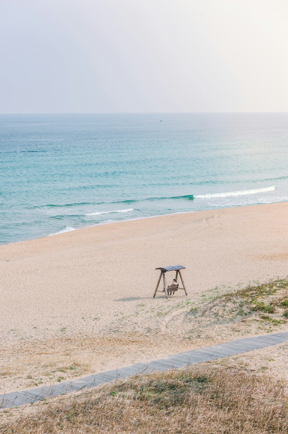 brown wooden bench on the seashore photography