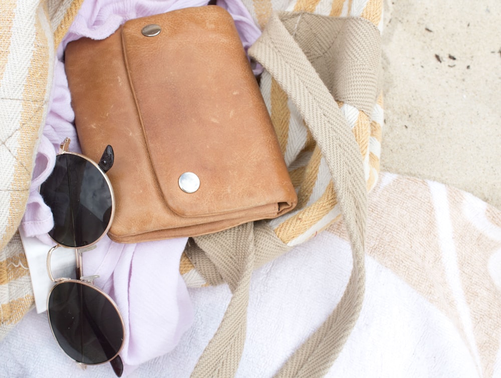 brown leather shoulder bag with dark sunglasses