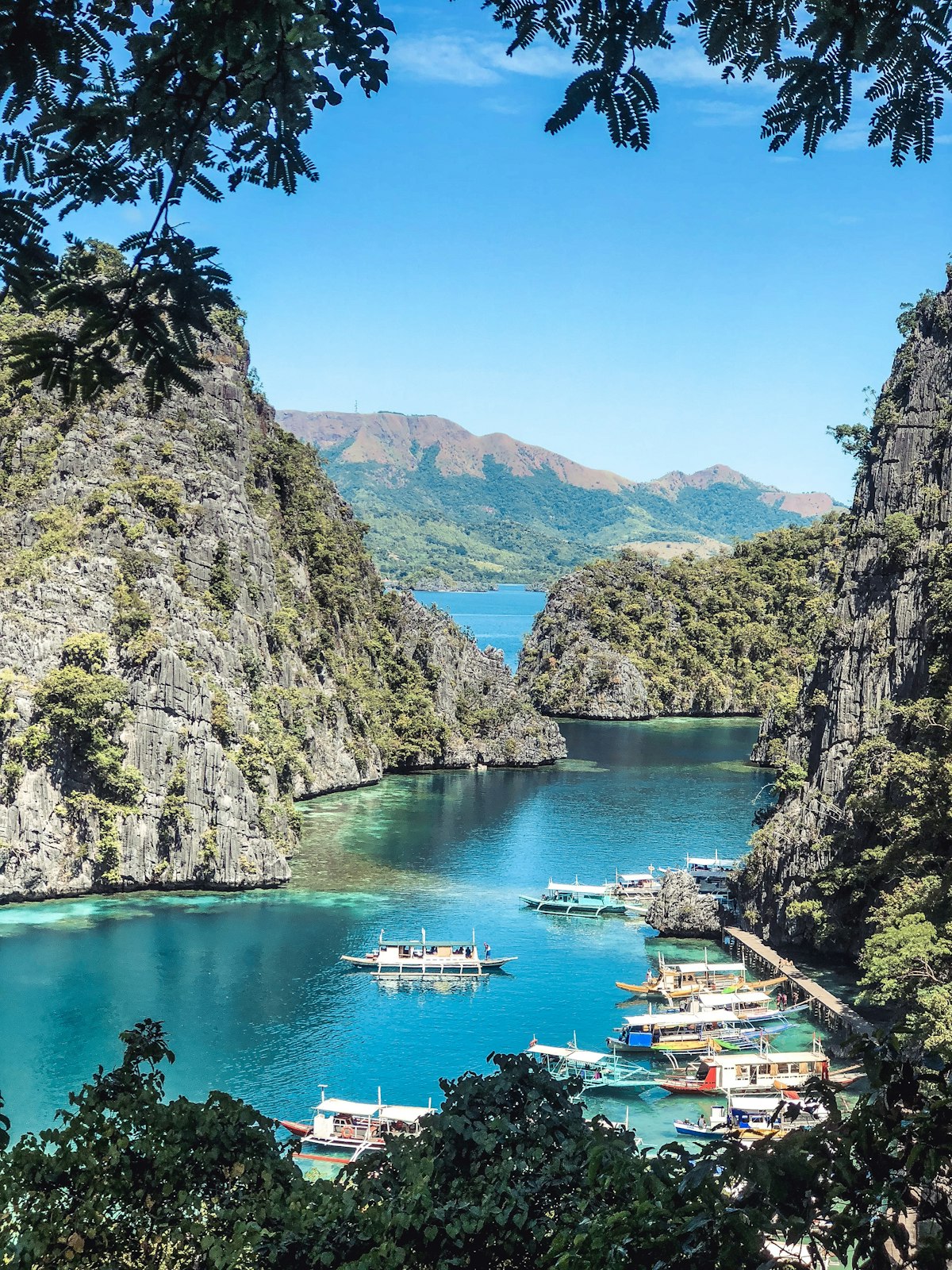 Coron Palawan — crystal-clear turquoise water at Kayangan Lake surrounded by limestone karst cliffs