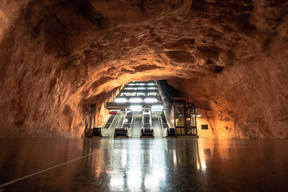 grey escalator inside brown cave