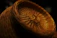 Close-up of a beautifully crafted handwoven basket displayed on a wooden shelf.