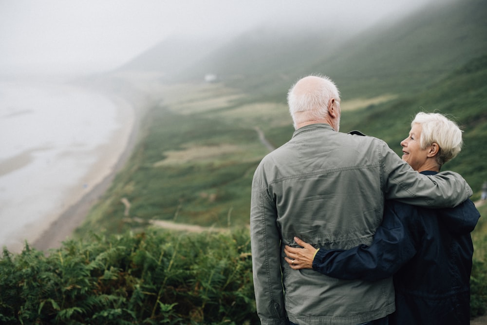 man and woman looking to each other on cliff