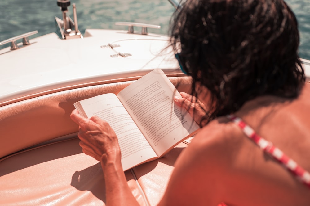 woman riding boat reading book