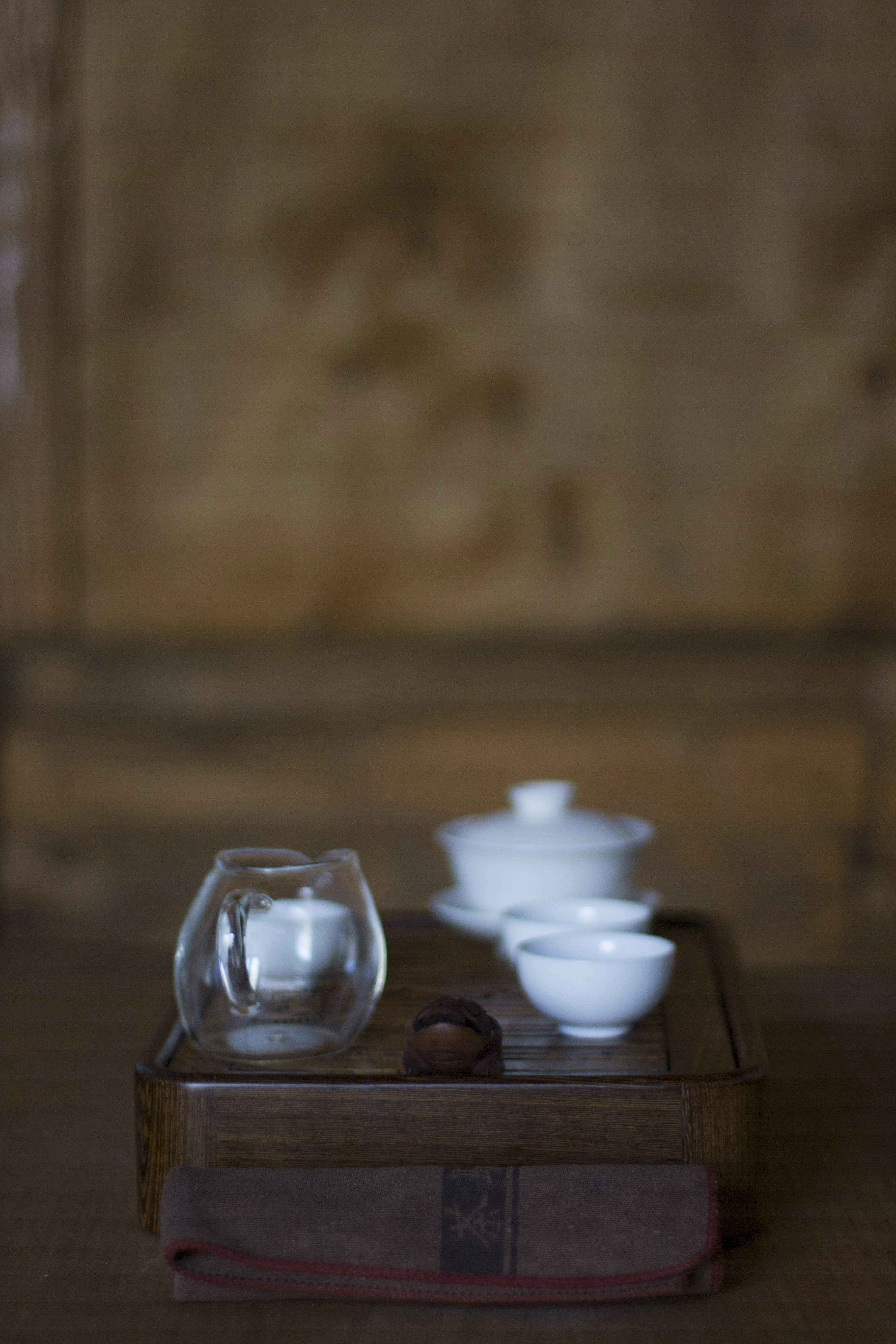 Minimalist white ceramic cup on dark wooden table, clean product photography