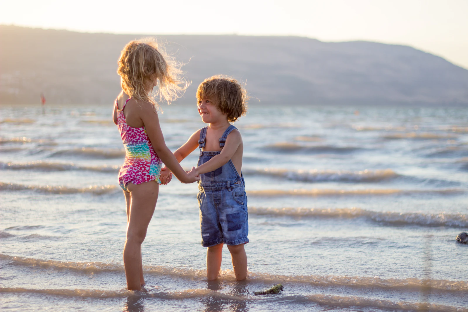 two children playing in the shallows of a lake