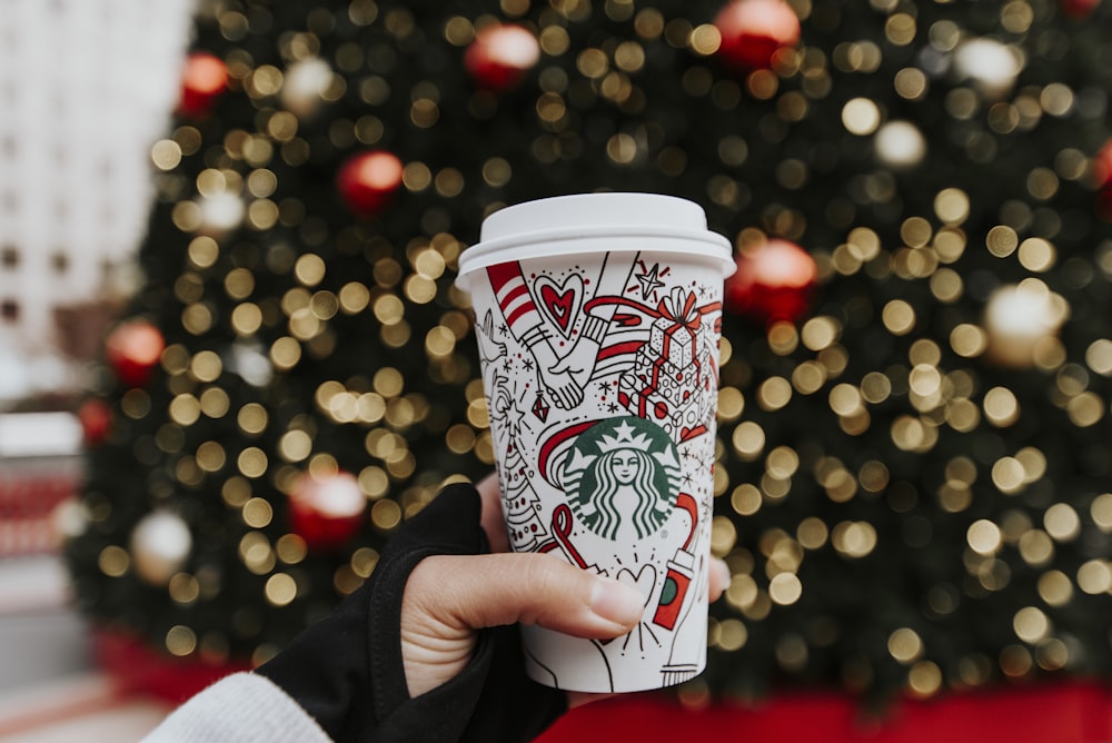 person holding white plastic cup