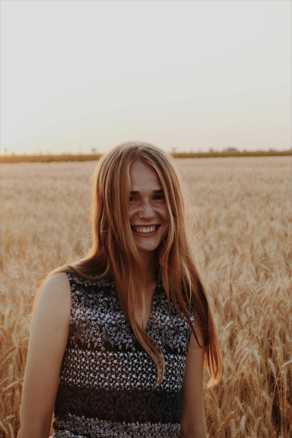 Donna sorridente in piedi sul campo di erba marrone