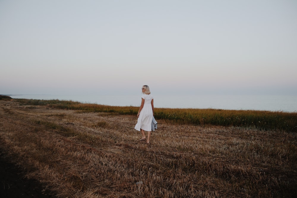 woman walking on brown grass field