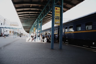 A Durgapur train platform with an arriving train and passengers boarding