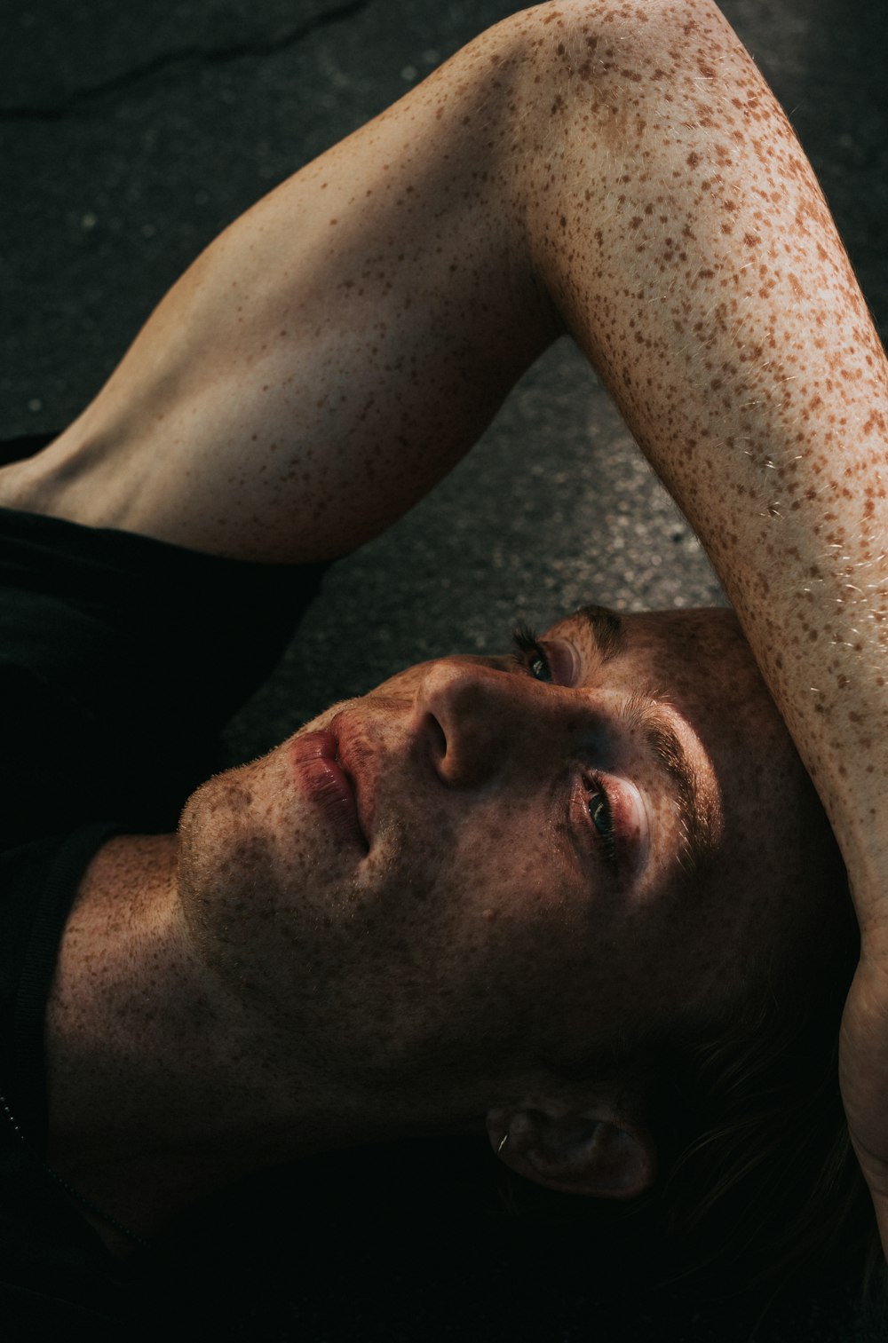 man lying on gray surface