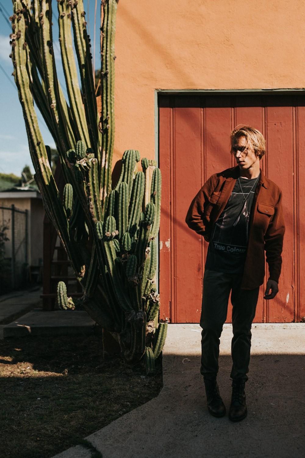 man standing beside cactus plant