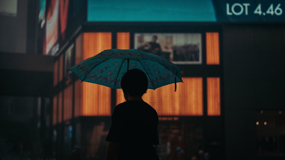 silhouette of person under umbrella