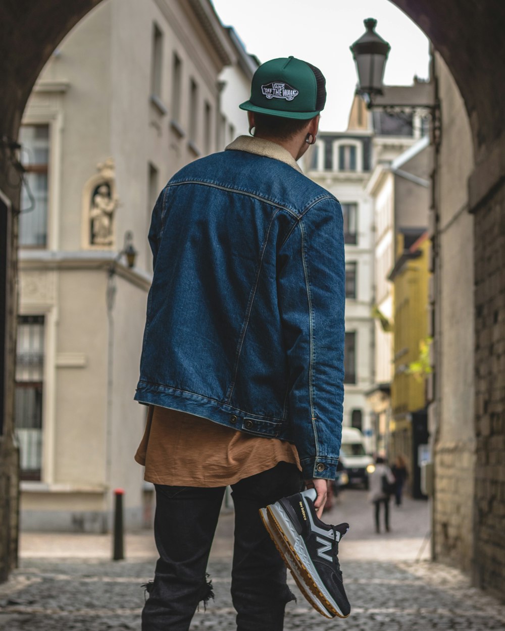 man holding New Balance sneakers