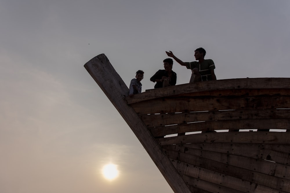 silhouette of people on top of building during sunset