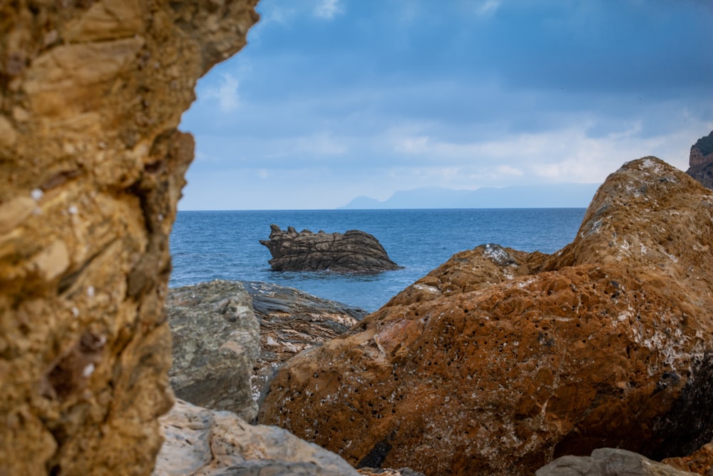 brown and grey rock formation near body of water