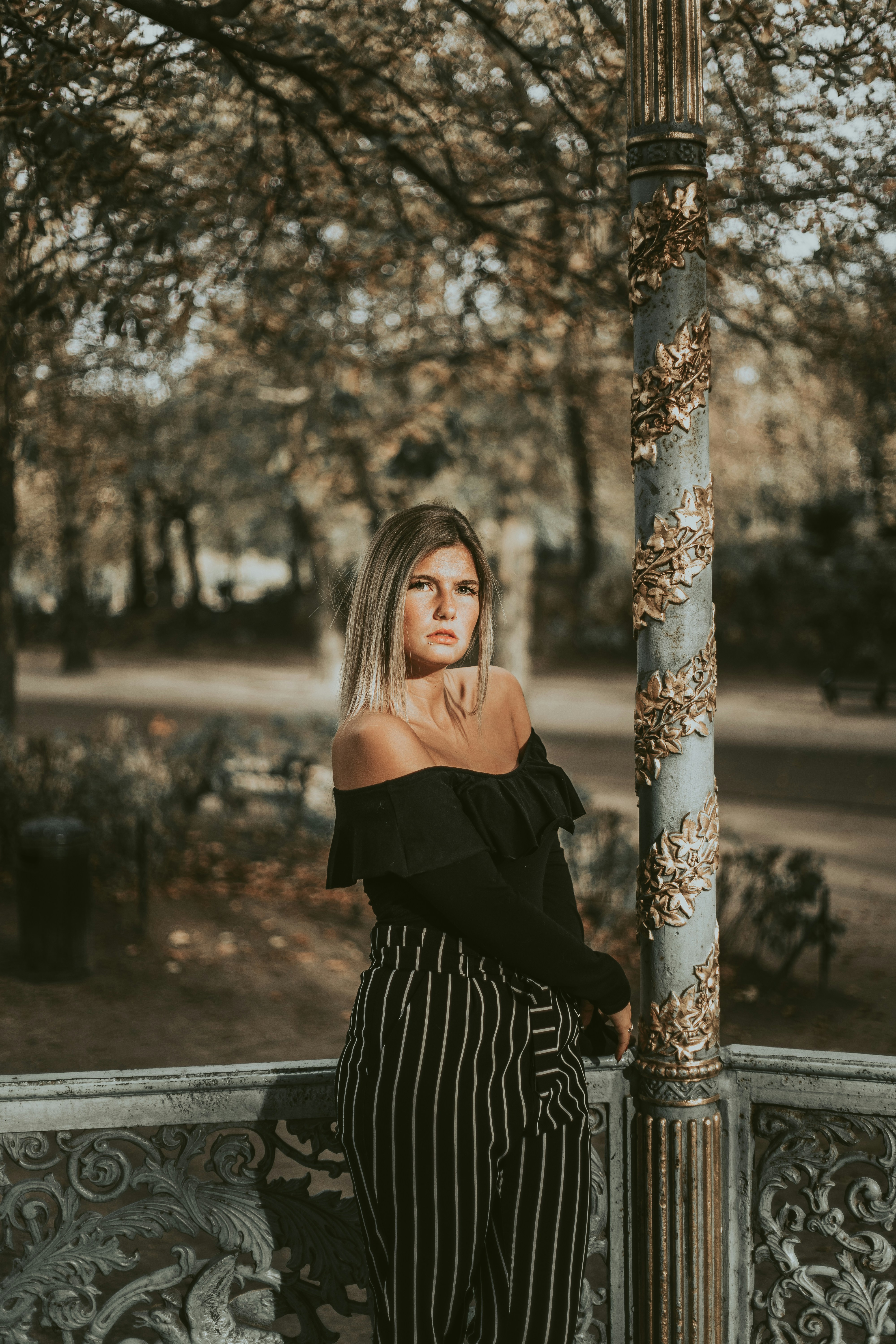 woman wearing black off-shoulder dress near trees