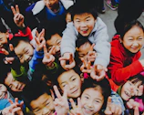 A group of children proudly showing their handmade crafts with big smiles