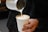 A close-up of a skilled barista pouring milk into coffee, creating stunning latte art.