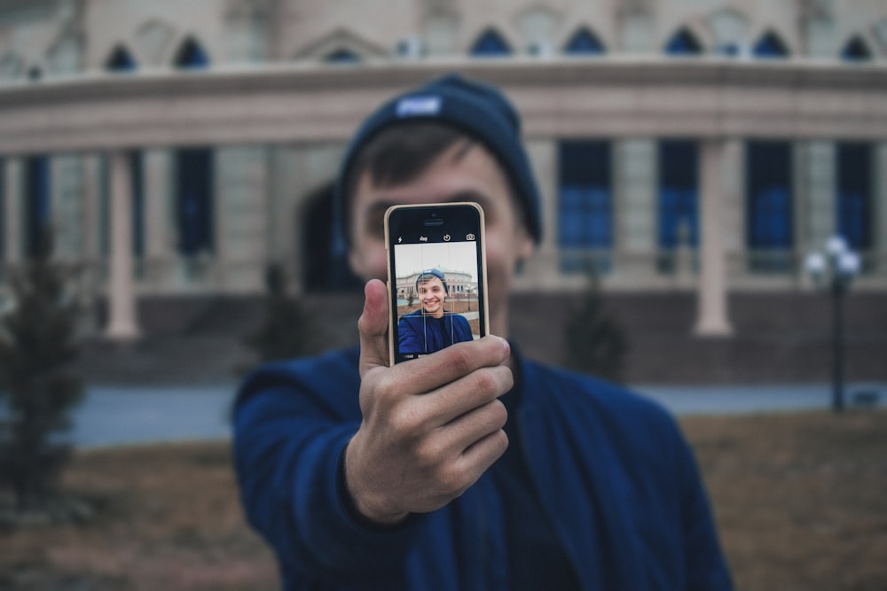 homme prenant une photo près d’un immeuble