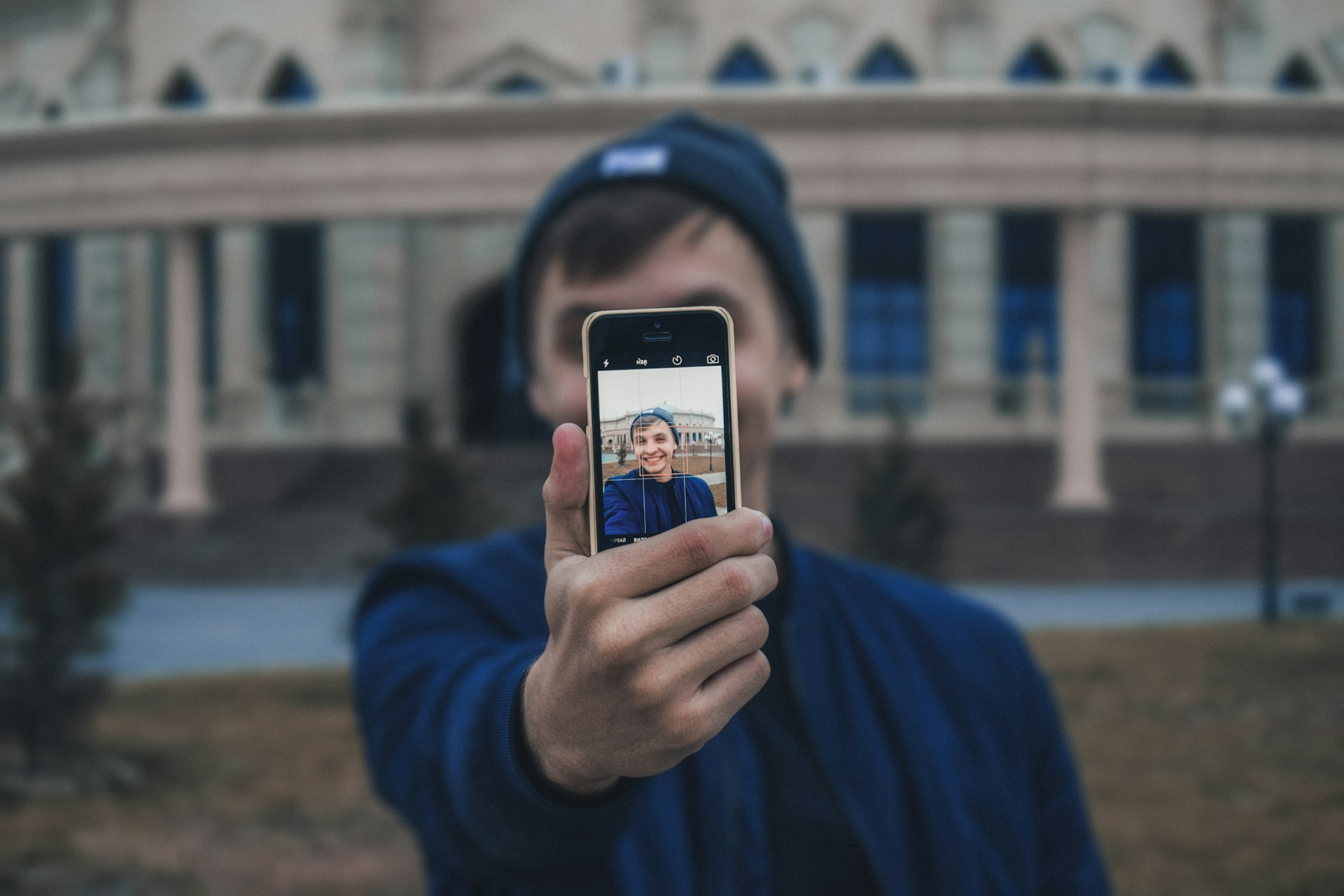 man taking photo near building