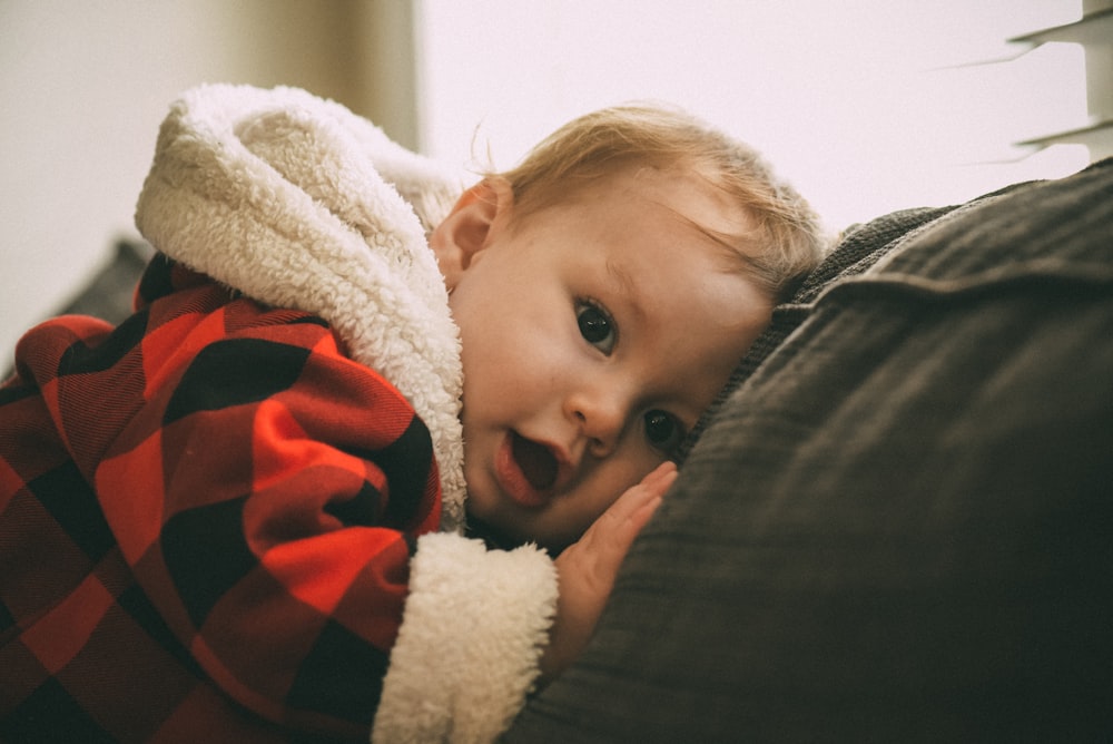 baby lying on black textile