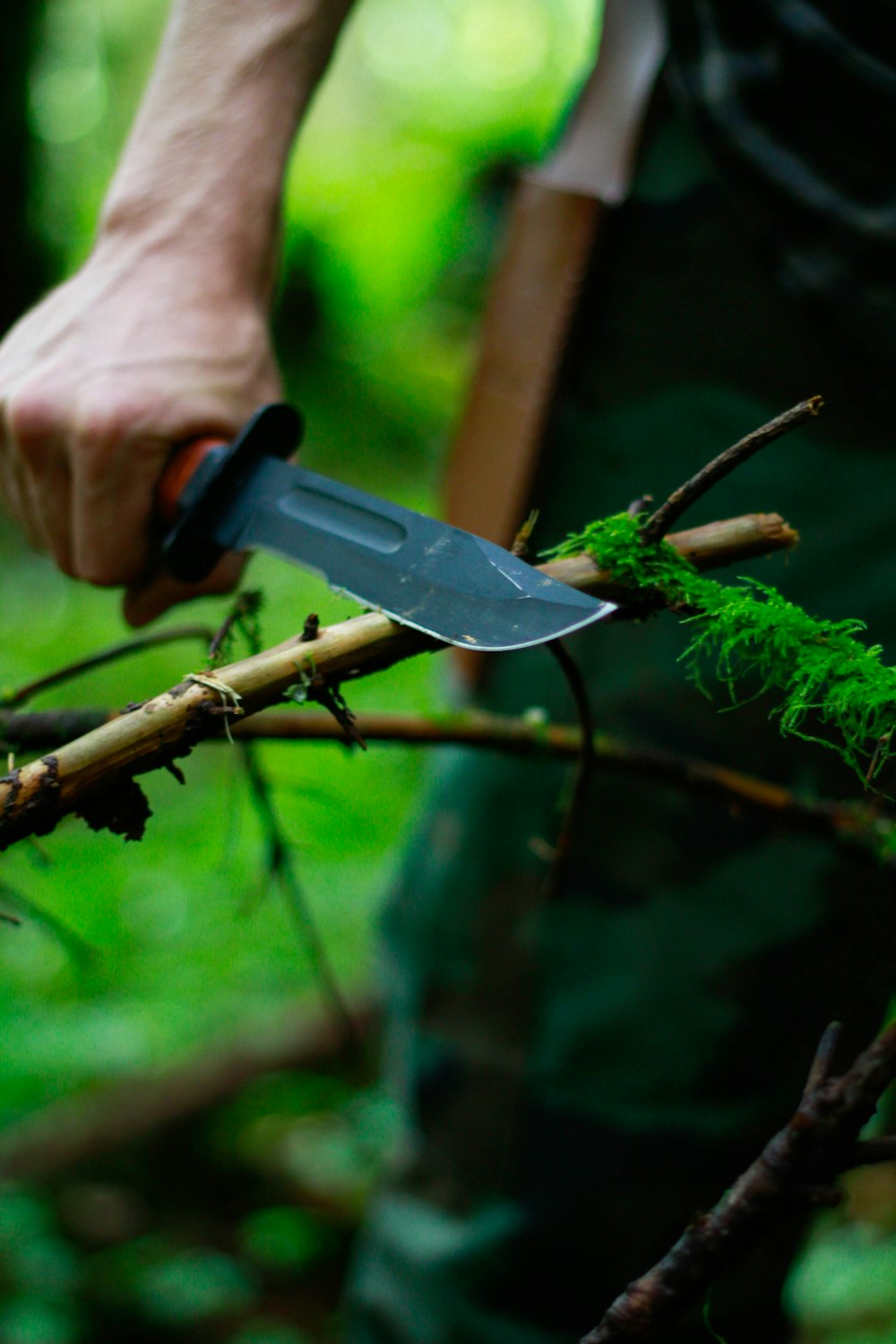 Mann mit Jagdmesser in der Nähe von Zweig