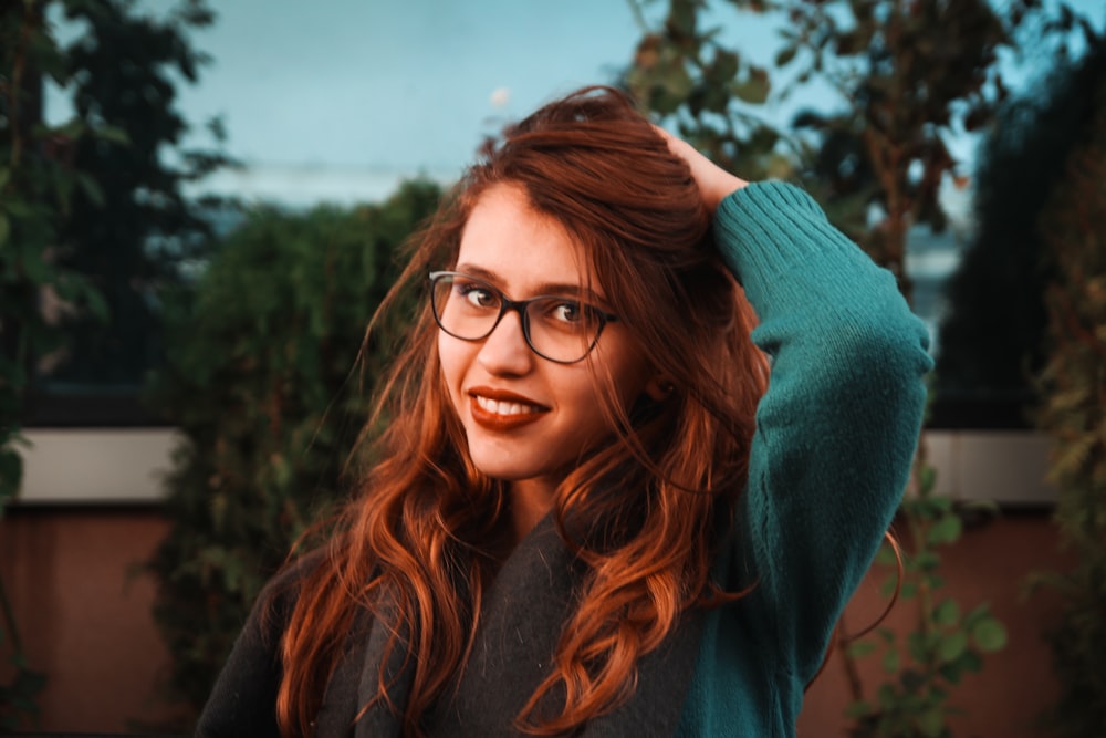 woman wearing eyeglasses and touching own hair