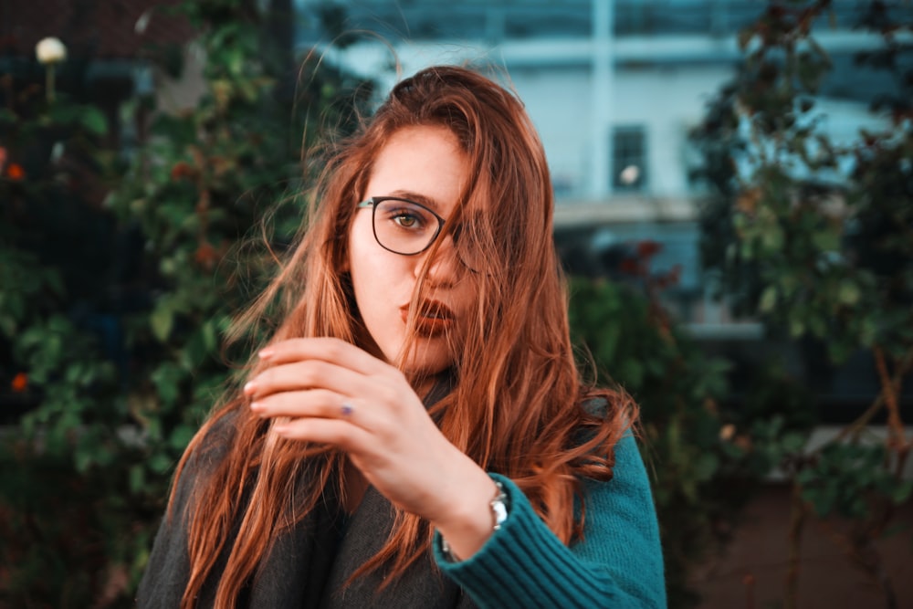 woman wearing teal sweater and eyeglasses