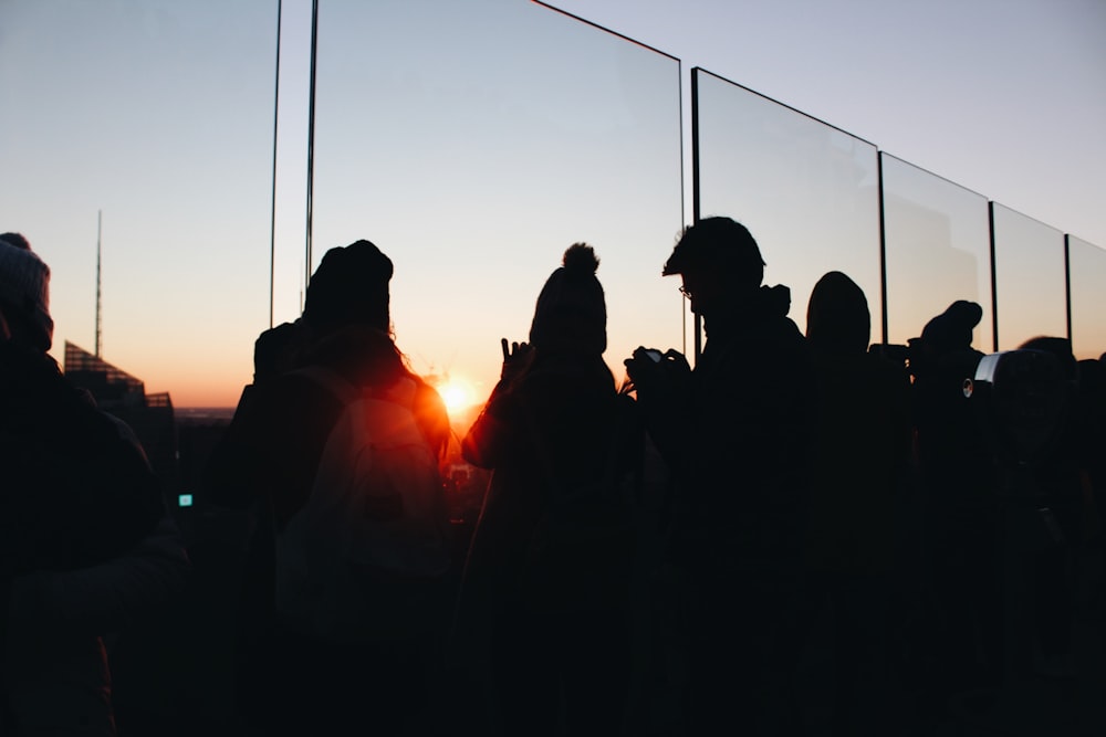 people gathering beside glass fence