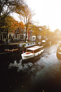 white boat on body of water near buildings during daytime