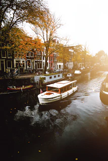 white boat on body of water near buildings during daytime