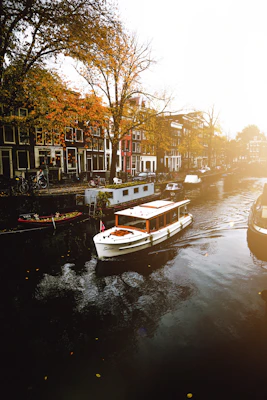 white boat on body of water near buildings during daytime