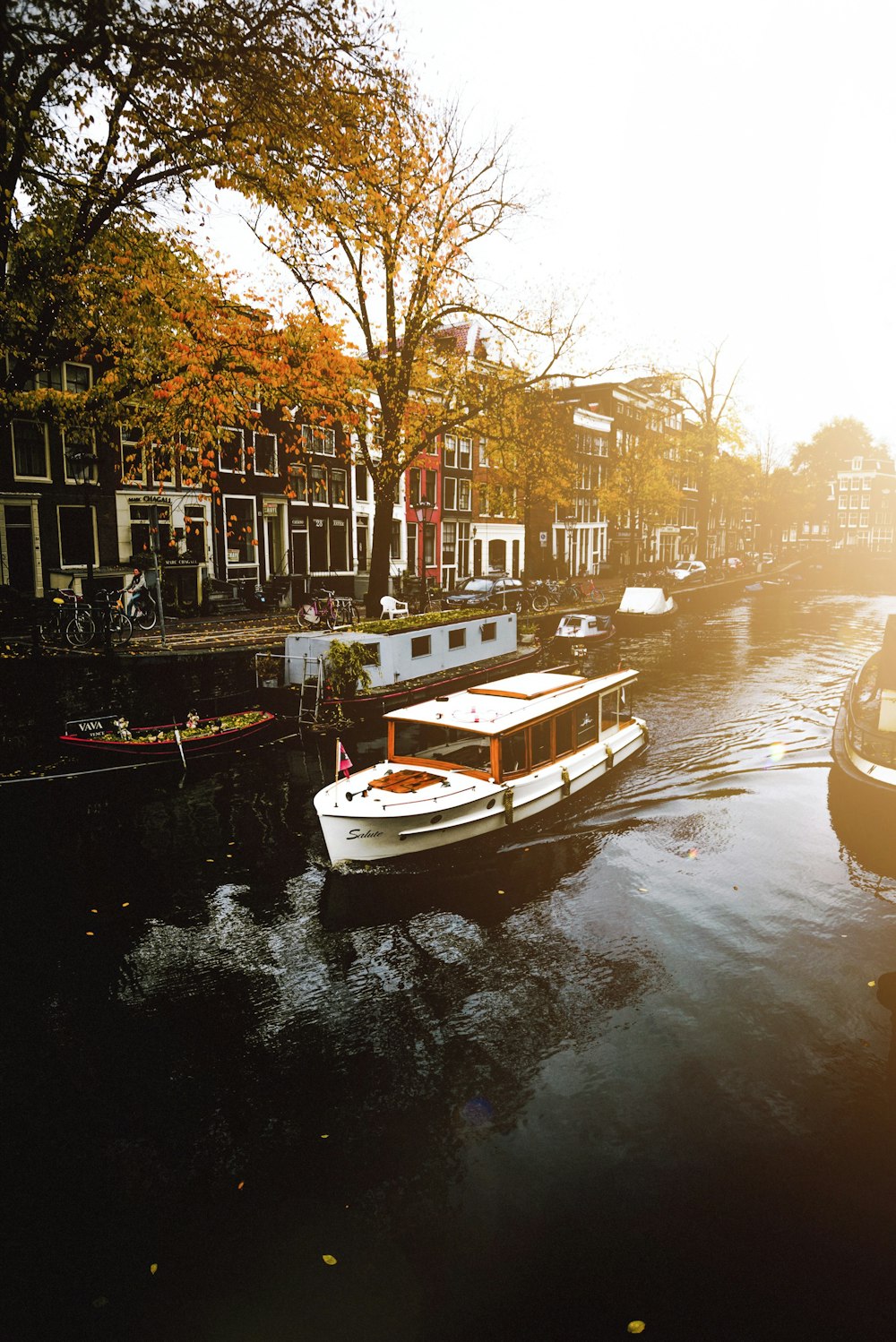 white boat on body of water near buildings during daytime