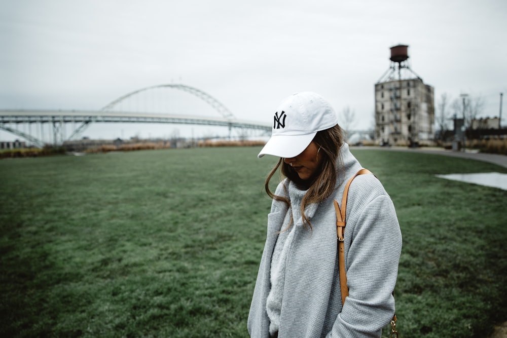 woman in grey sweater looking down at daytime