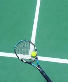 tennis racket and ball on field