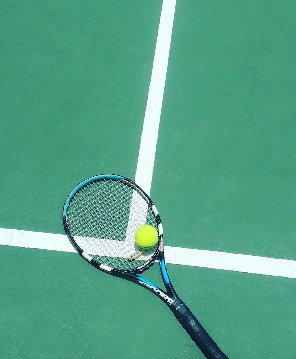 racchetta da tennis e pallina sul campo