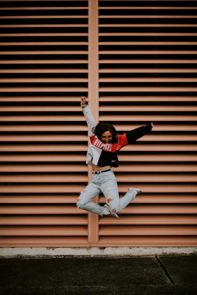 A vibrant photo of a person joyfully hopping on a colorful žingsnis mat in a sunlit room.