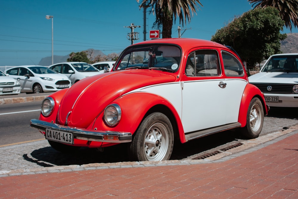 Volkswagen fusca vermelho e branco estacionado no acostamento da estrada