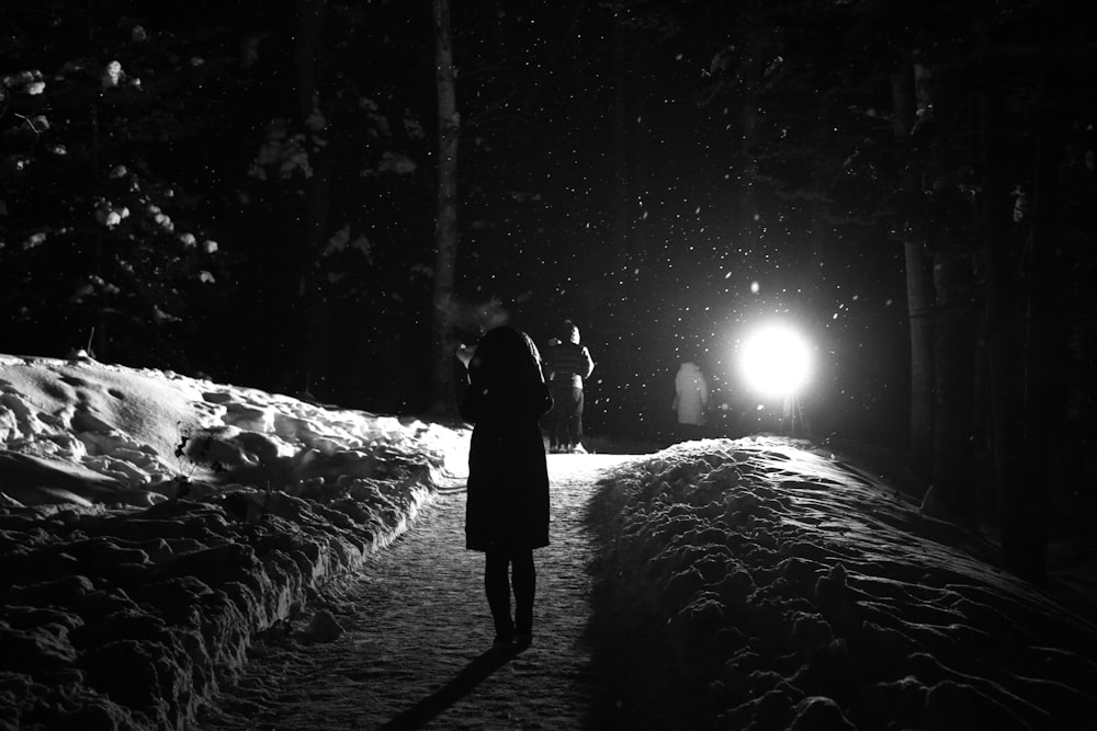 una persona in piedi nella neve di notte