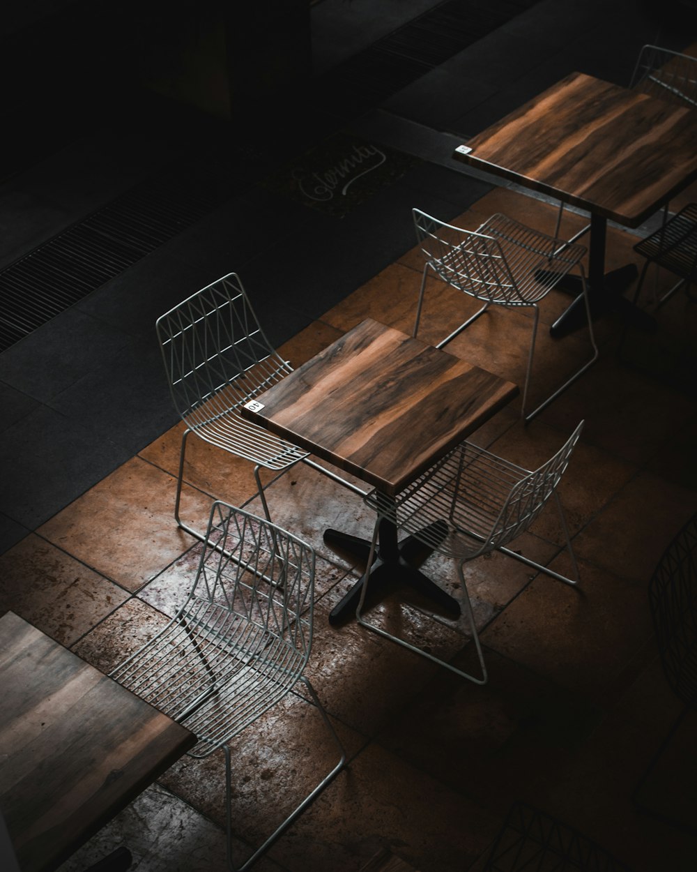 茶色の床に椅子が置かれたテーブル